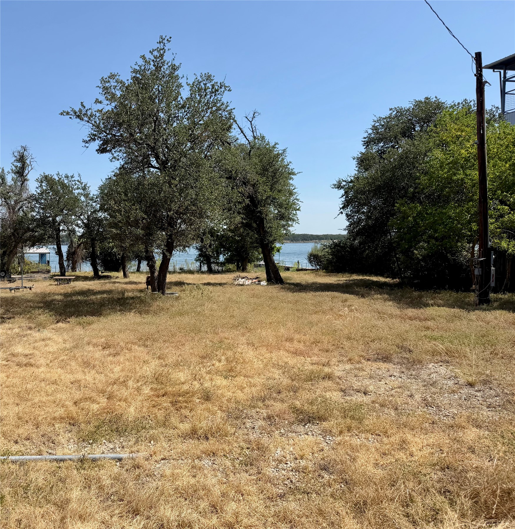 1809 Graveyard Point Road Austin, TX 78734 - Photo 1 of 1 Mature trees frame a grassy slope leading directly down to calm waterfront views.