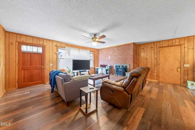 a living room with furniture a large window and a flat screen tv