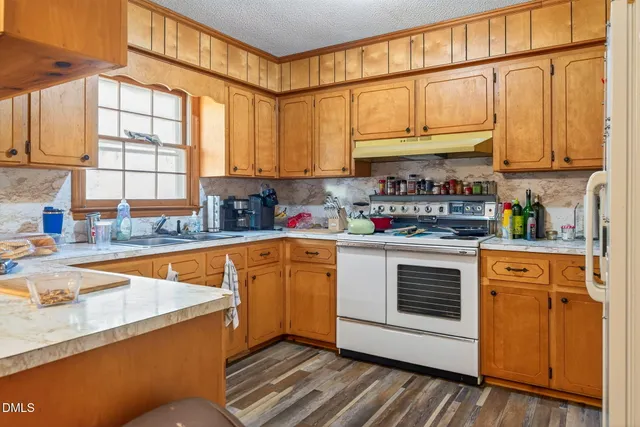 a kitchen with stainless steel appliances granite countertop a sink a stove and cabinets