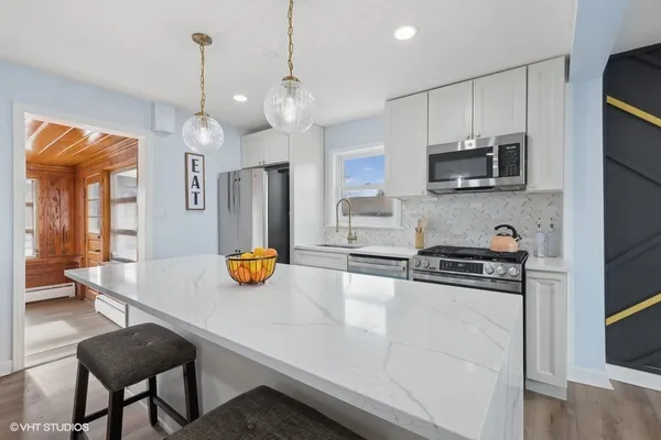 a kitchen with stainless steel appliances granite countertop a sink a stove and a refrigerator