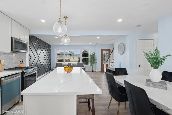 a large white kitchen with a table and chairs