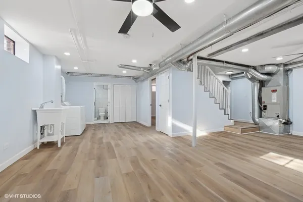 an empty room with wooden floor a ceiling fan a fireplace
