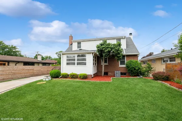 a front view of a house with a yard and green space