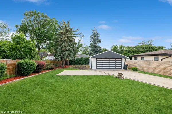 a front view of a house with a yard and trees