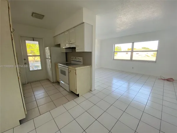 an empty room with windows and cabinet