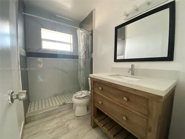 a bathroom with a toilet sink and mirror