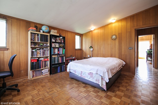 1655 Sunset Ridge Road Northbrook, IL 60062 - Photo 7 of 12 a spacious bedroom with a bed and a bookshelf