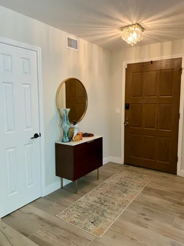 a living room with a dresser and a chandelier