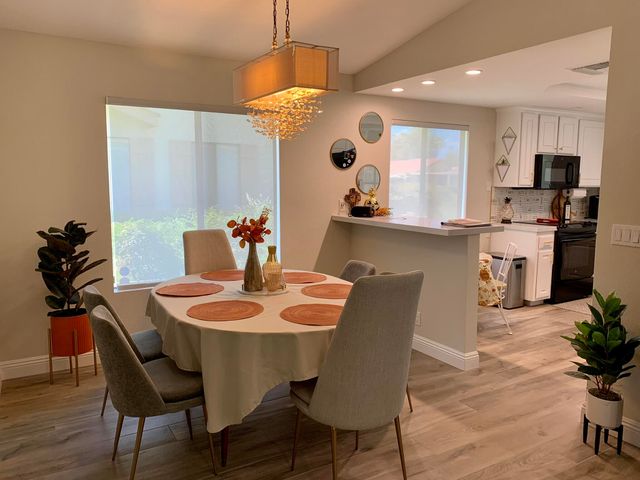 a dining room with furniture potted plants and wooden floor