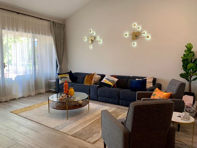 a living room with furniture a chandelier and a window
