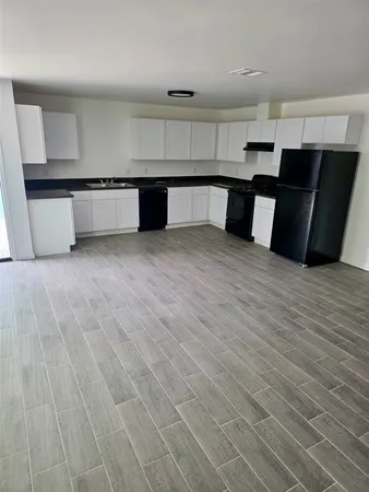 a large kitchen with a sink and cabinets
