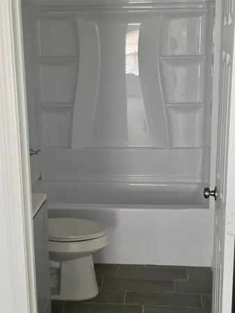 a bathroom with a toilet and a window