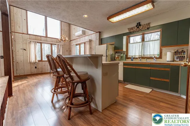 a kitchen with stainless steel appliances granite countertop a stove a sink dishwasher and a refrigerator with wooden floor