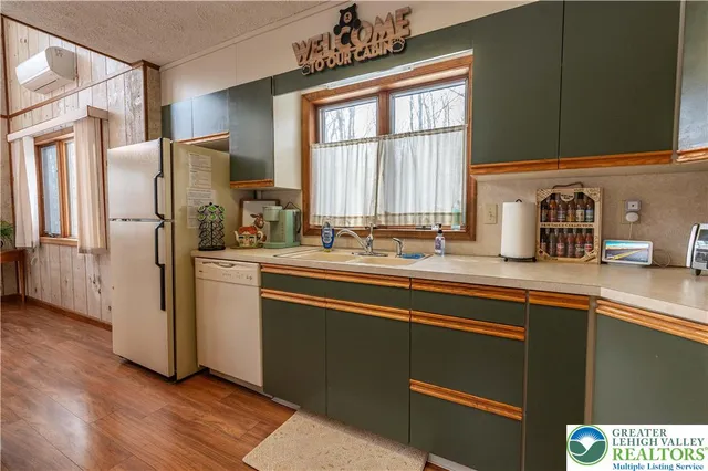 a kitchen with stainless steel appliances a sink cabinets and a window