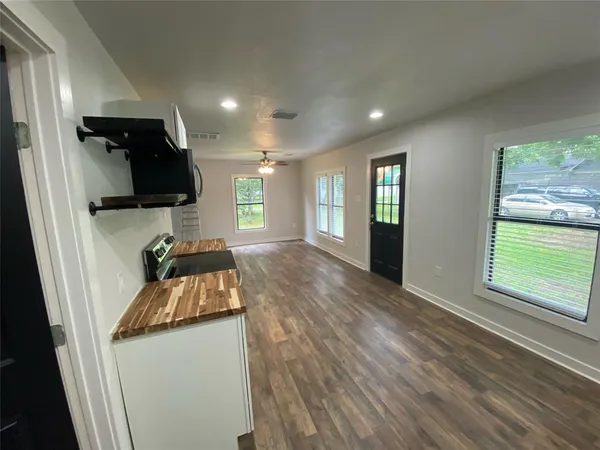 a view of a livingroom with a window and wooden floor