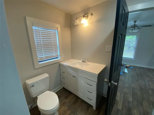 a bathroom with a toilet a sink a vanity and mirror