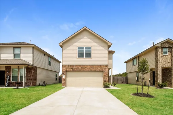 a front view of a house with a yard and garage