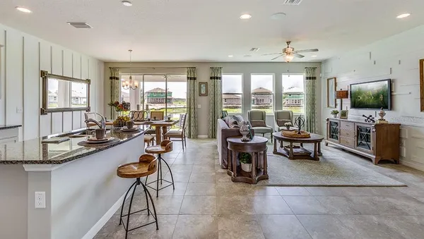 a living room with furniture a flat screen tv and a large window