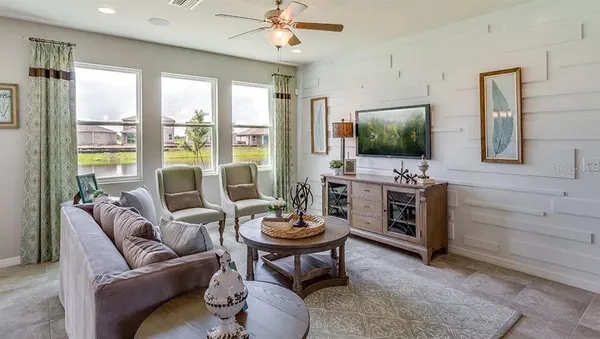 a living room with furniture a flat screen tv and a large window