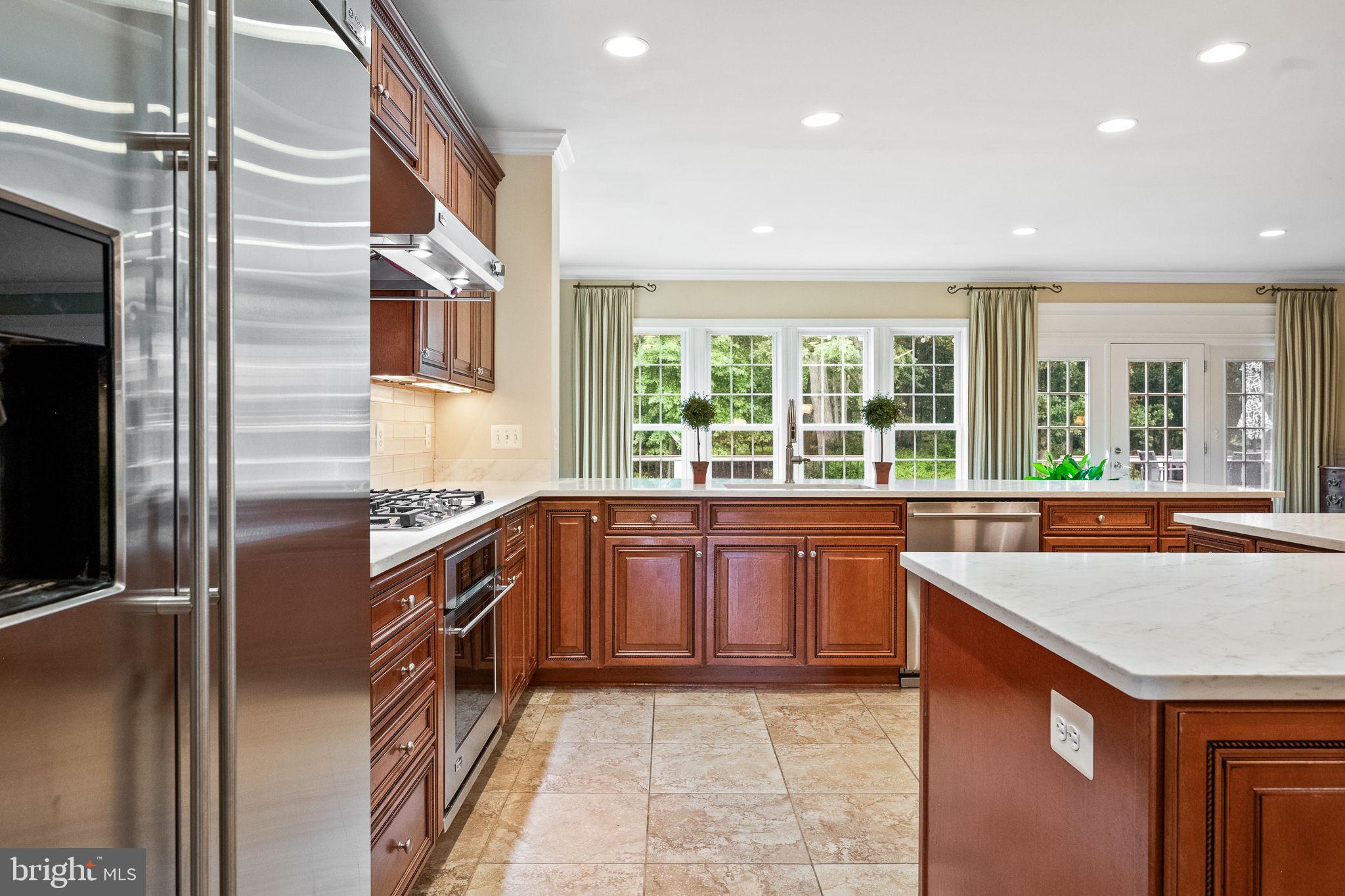 20899 McIntosh Place Leesburg, VA 20175 - Photo 15 of 69 a large kitchen with stainless steel appliances granite countertop a sink and a stove
