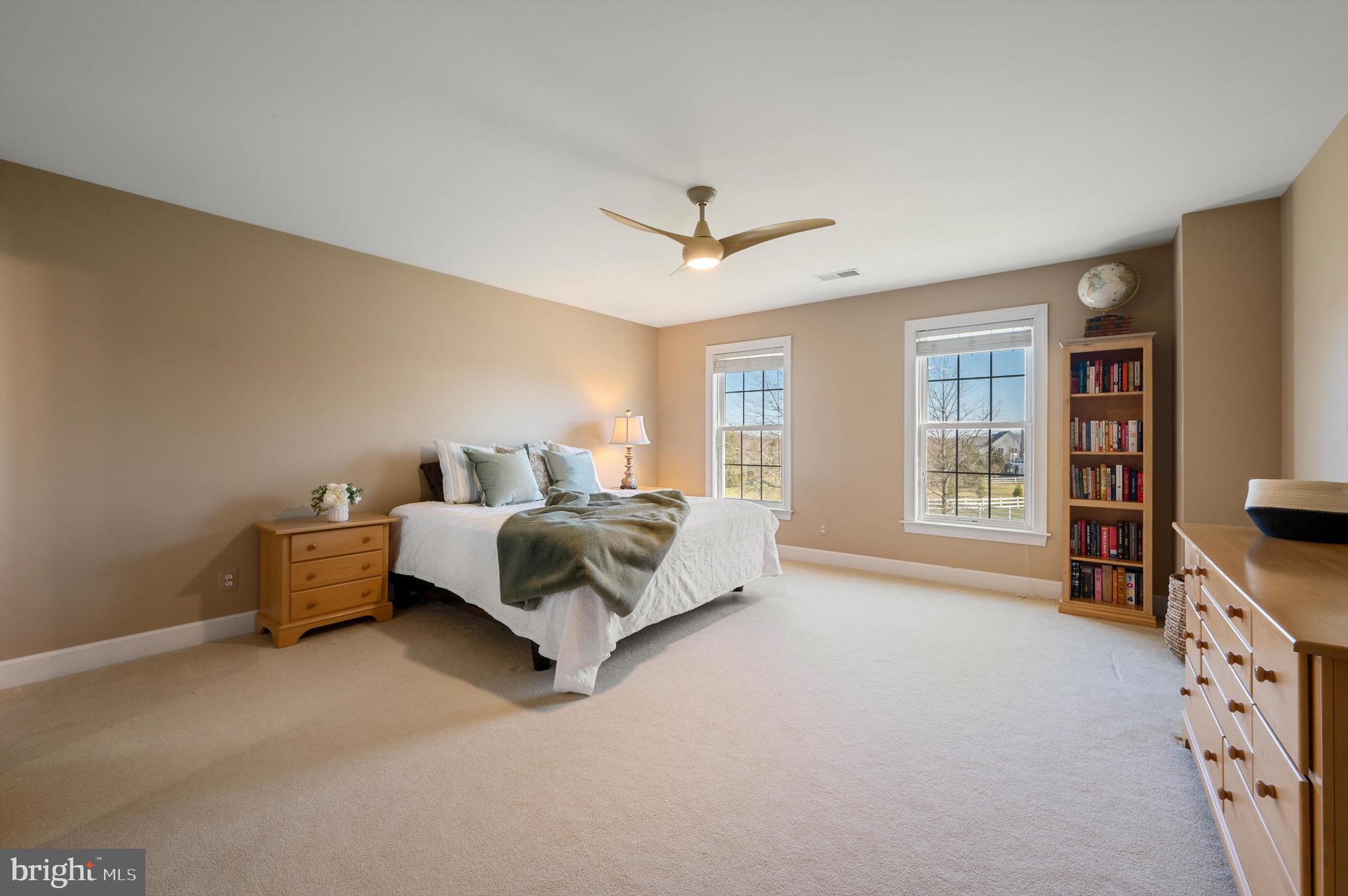 20899 McIntosh Place Leesburg, VA 20175 - Photo 32 of 69 a spacious bedroom with a bed and a couch