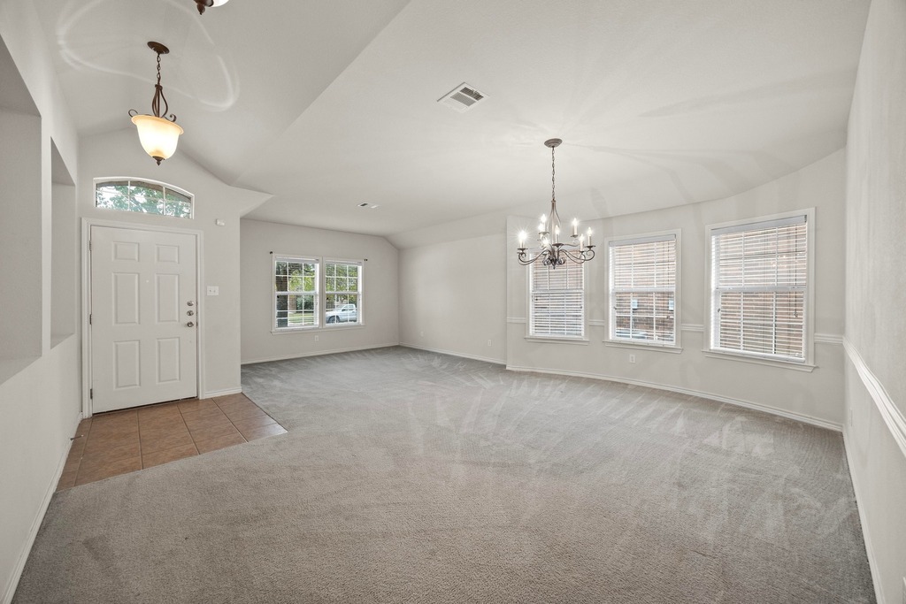 2832 Mission Tejas Drive Pflugerville, TX 78660 - Photo 13 of 30 an empty room with windows and chandelier