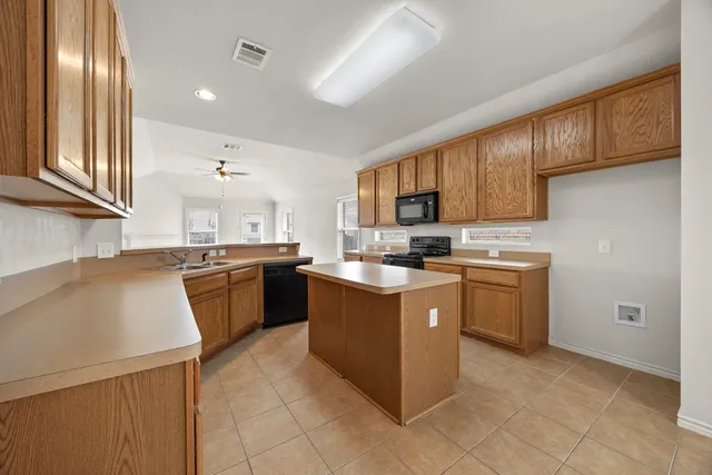 a kitchen with stainless steel appliances granite countertop a stove refrigerator sink and cabinets