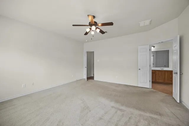 a view of an empty room with a ceiling fan