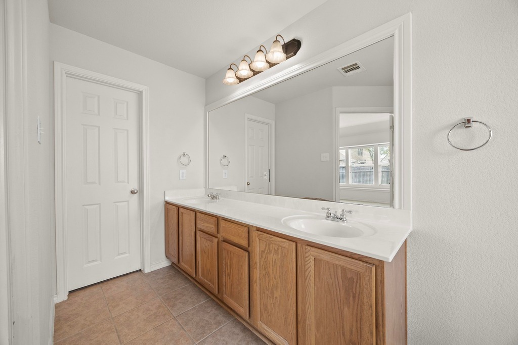 2832 Mission Tejas Drive Pflugerville, TX 78660 - Photo 22 of 30 a bathroom with a sink and a mirror