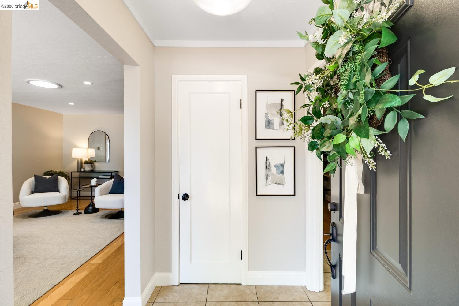 346 Valley View Road Pleasant Hill, CA 94523 - Photo 8 of 57 Entryway featuring tile flooring, a solid panel interior door with matte black hardware, and an arched doorway opening to a room with wood-finish flooring and recessed lighting