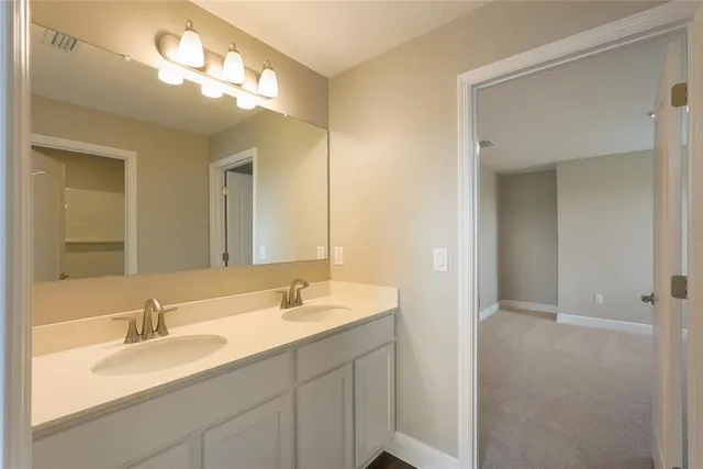 a bathroom with double vanity sink and a mirror