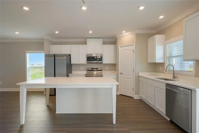 a large kitchen with stainless steel appliances granite countertop a large center island and a sink