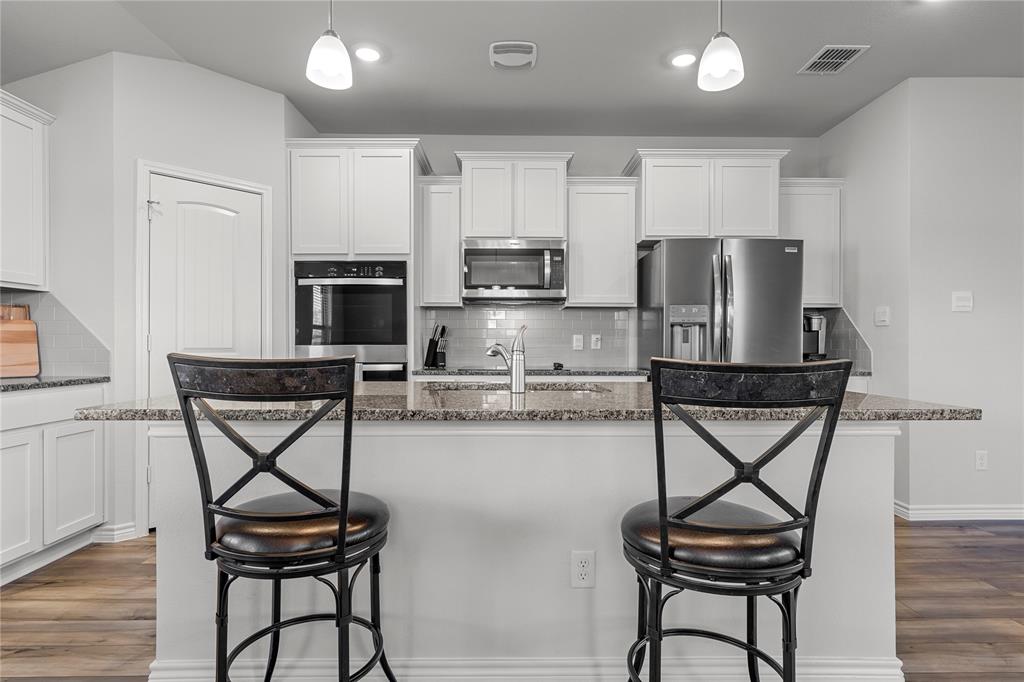 10761 Chesson Flts Drive Waco, TX 76708 - Photo 17 of 30 a kitchen with stainless steel appliances wooden cabinets and chairs