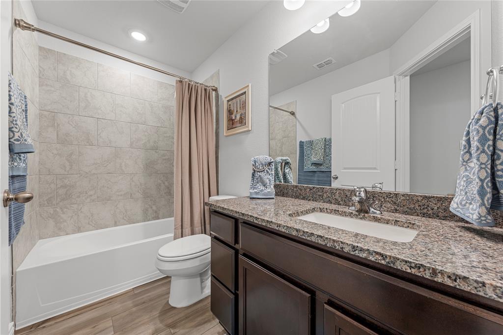 10761 Chesson Flts Drive Waco, TX 76708 - Photo 21 of 30 a bathroom with a granite countertop sink a toilet and bathtub