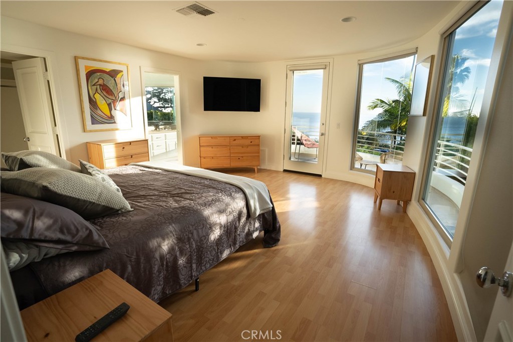 558 Cliff Drive Laguna Beach, CA 92651 - Photo 12 of 25 a bedroom with a bed and wooden floor