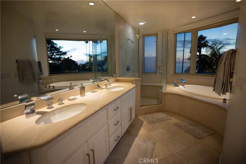 558 Cliff Drive Laguna Beach, CA 92651 - Photo 13 of 25 a bathroom with a double vanity sink a mirror and a bathtub