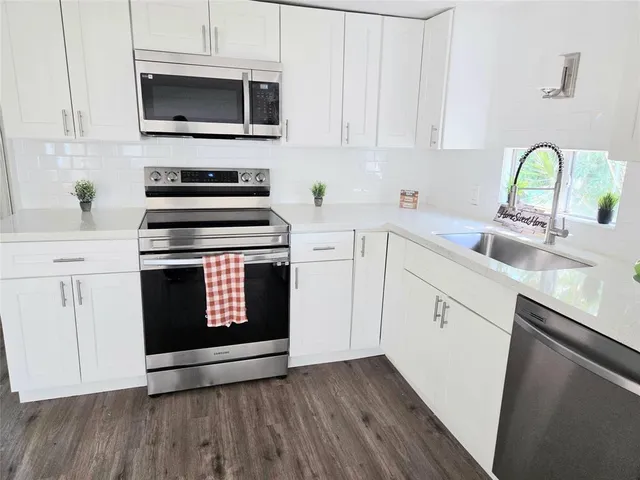 a kitchen with a stove microwave and sink