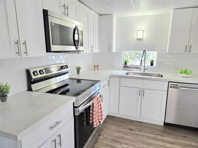 a kitchen with stainless steel appliances granite countertop a sink stove and microwave