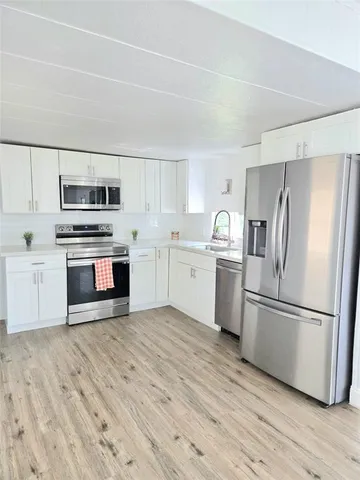 a kitchen with granite countertop a refrigerator oven a sink and dishwasher