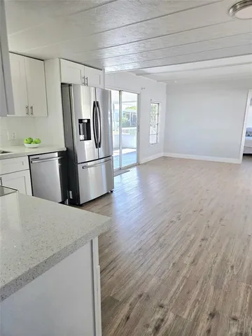 a kitchen with stainless steel appliances granite countertop a refrigerator a stove and a sink with large refrigerator