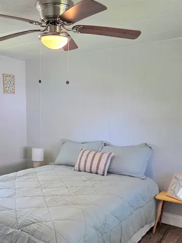 a bedroom with a bed and a chandelier fan