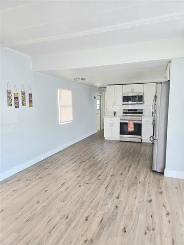 a view of a kitchen with wooden cabinet and a stove top oven