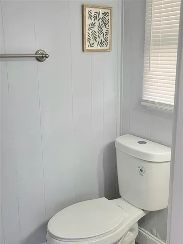 a white toilet sitting next to a shower