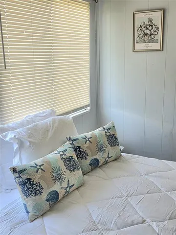a bed sitting in a bedroom next to a window