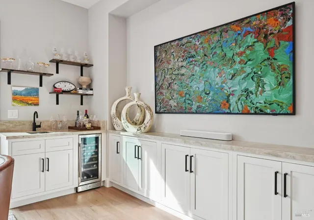 a kitchen with white cabinets and sink