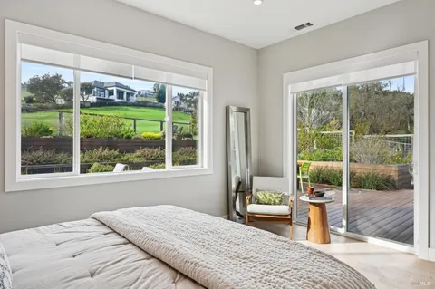a bedroom with a bed and large windows