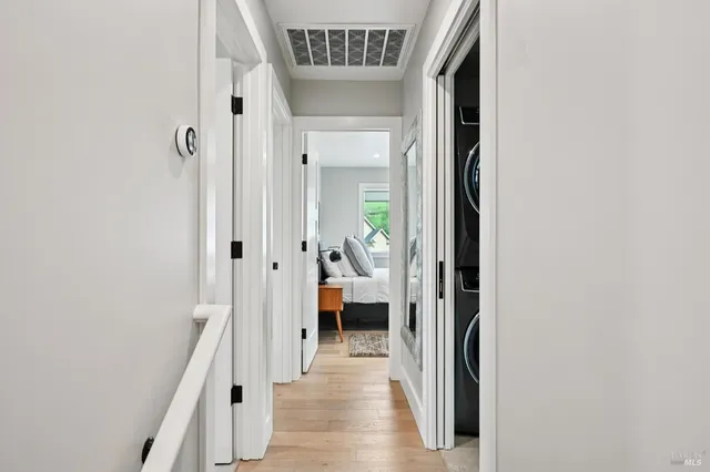 a view of a hallway with wooden floor and a livingroom