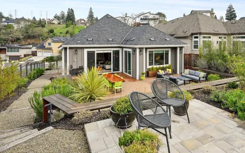 a view of a house with backyard sitting area and garden