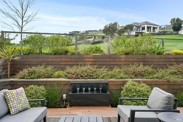 a view of a two chairs in the deck next to a yard