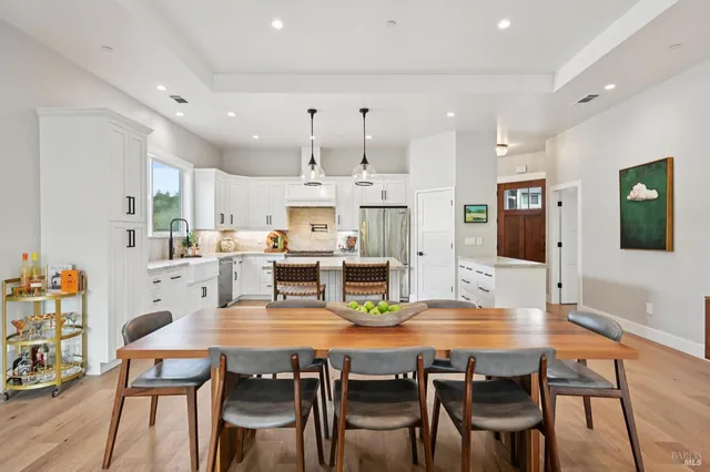 a kitchen with stainless steel appliances kitchen island granite countertop a dining table chairs and view living room